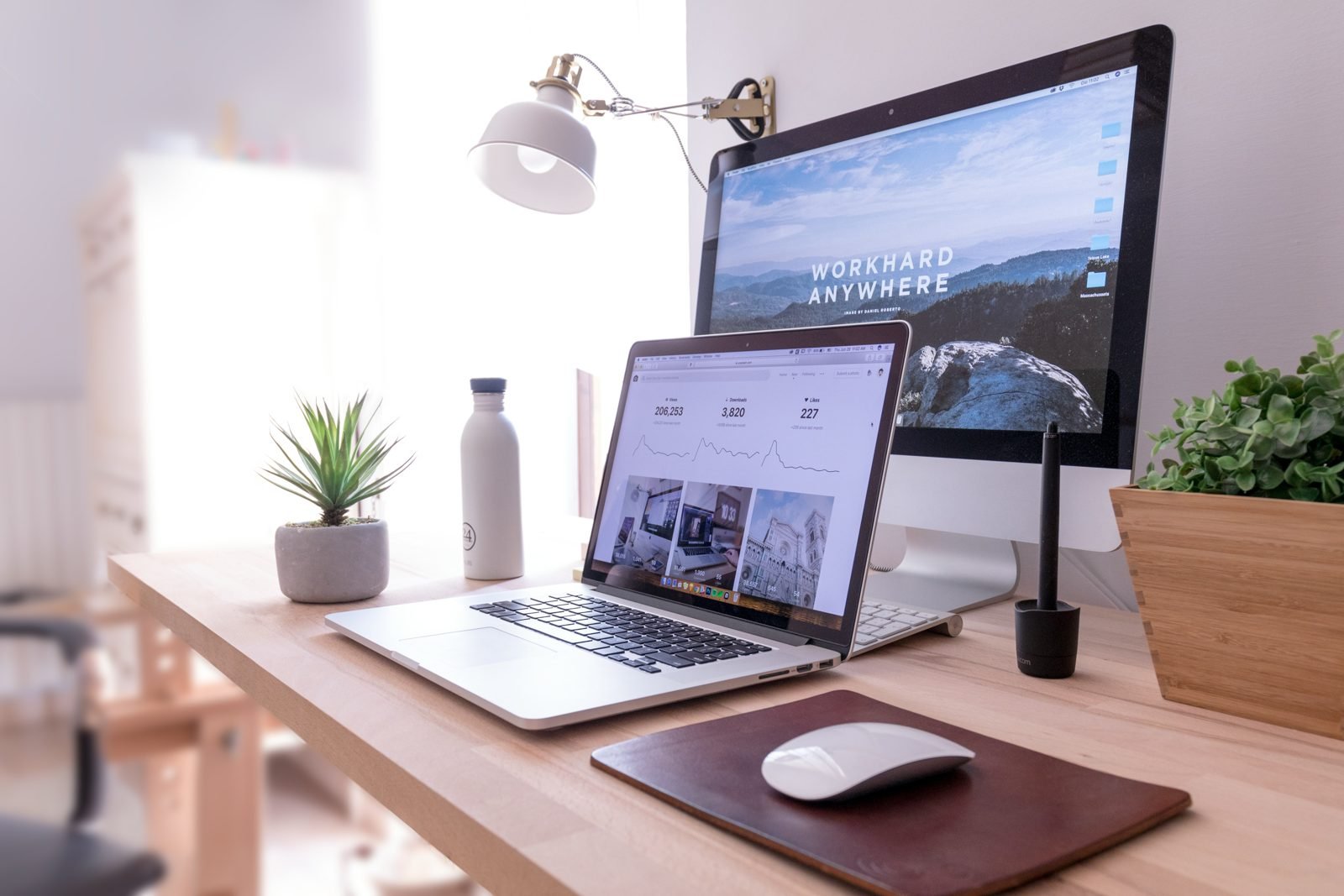 Modern workspace with laptop, iMac and desk lamp